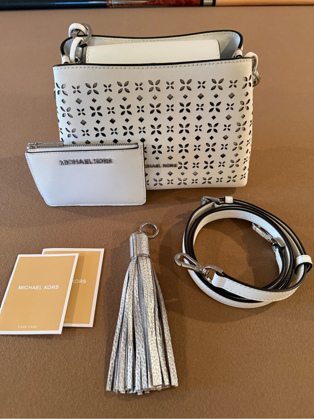 Michael Kors White Perforated Crossbody with Silver Tassel Charm